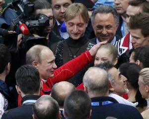 Yulia Lipnitskaya and Evgeny Plyushchenko with Russia's figure skating team is greeted Russia's President Vladimir Putin at the Sochi 2014 Winter Olympics
